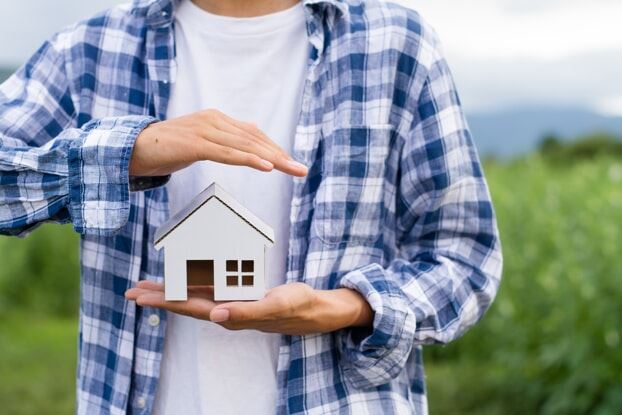 Man holding figurine of house